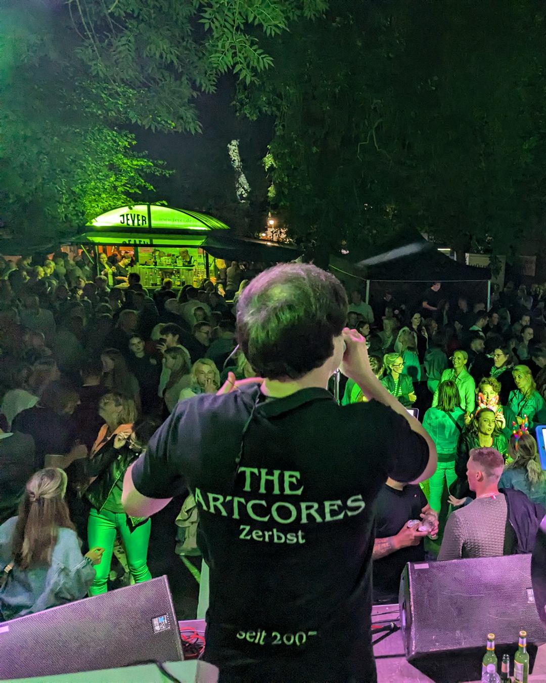 The Artcores von hinten auf der Bühne beim Altstadtfest Jever 2024, vor ihnen ein voller Platz mit Publikum